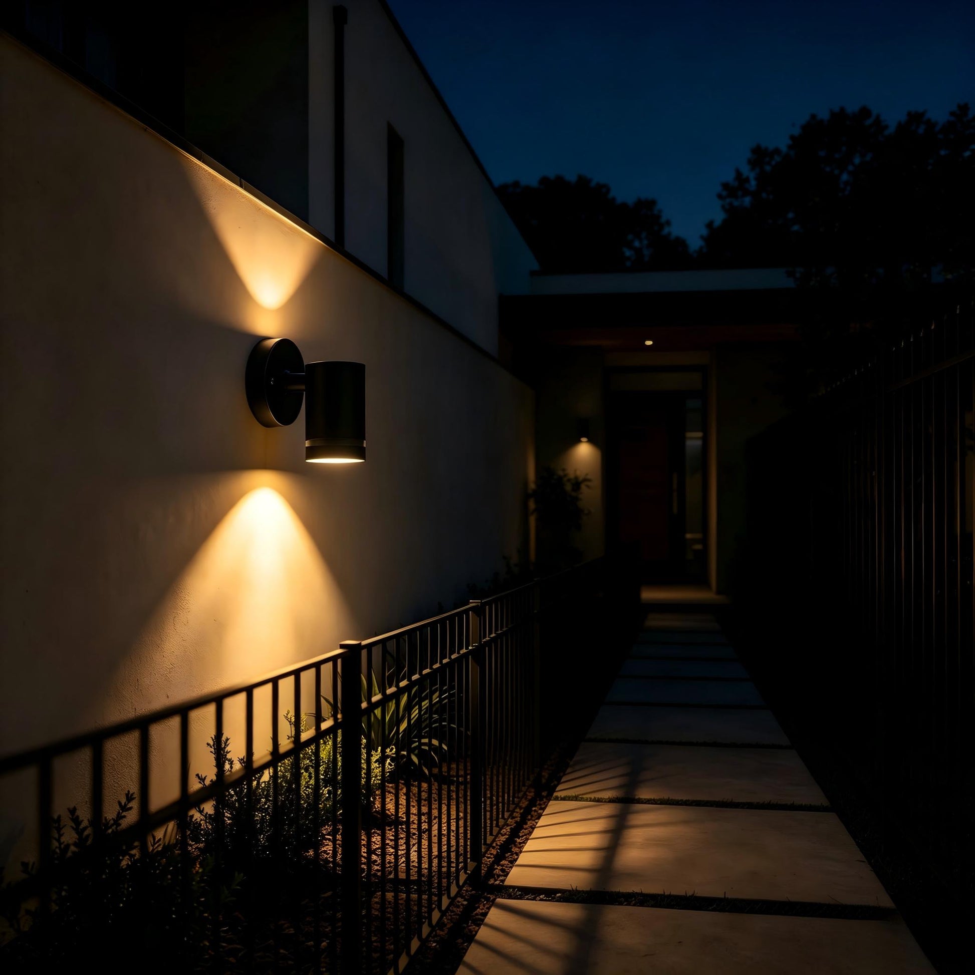 Black modern exterior sconce glowing warm light, terrace night close-up