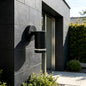 Illuminated black outdoor cylinder light at front gate entrance wide night view
